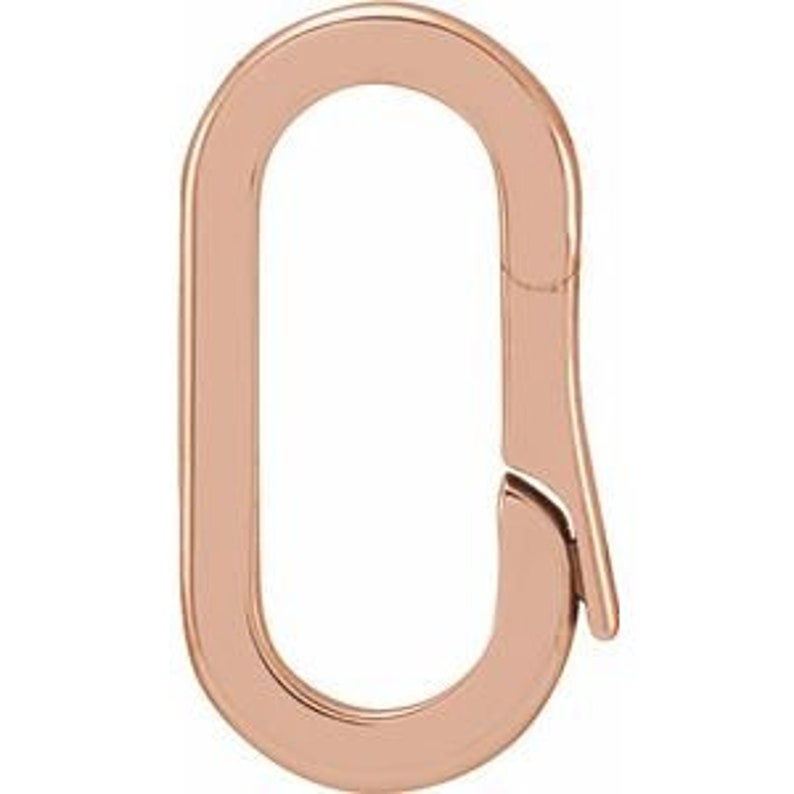 May include: A rose gold oval-shaped clasp with a hinged opening. The clasp is smooth and polished, designed for jewelry or accessories. The metal has a warm, reflective sheen.
