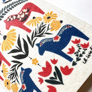 May include: A white background with a repeating pattern of red and blue stylized horses, flowers, and leaves. The text "L. Walker" is in the bottom right corner.