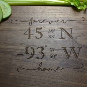 May include: A wooden chopping board with the text "forever home" engraved on it. The coordinates 45° 39' 33" N -93° 37' 50" W are also engraved on the board.