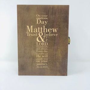 May include: A wooden box with a gold inscription that reads "On your christening day Matthew Trust & believe in the Lord Unconditionally and always. Every day be thankful and He will guide you on your journey. 05.12.2019"