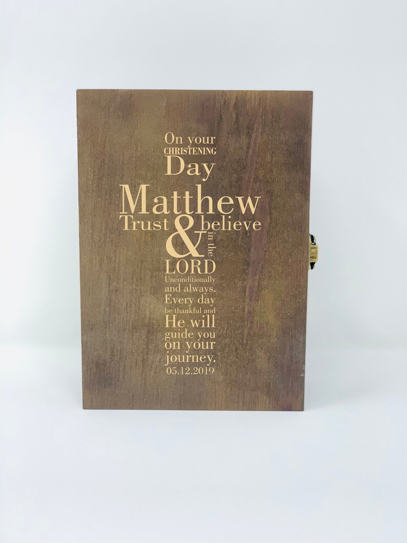 May include: A wooden box with a gold inscription that reads "On your christening day Matthew Trust & believe in the Lord Unconditionally and always. Every day be thankful and He will guide you on your journey. 05.12.2019"