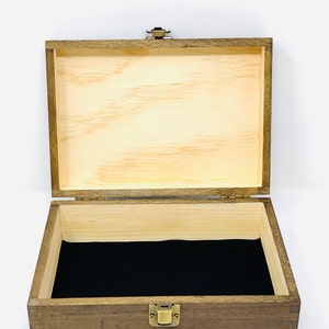 May include: A wooden box with a hinged lid and a brass latch. The box is open and the inside is lined with black velvet.