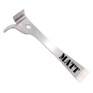 May include: A silver metal tool with a curved handle and a flat blade. The blade has the word "MATT" printed on it in black.