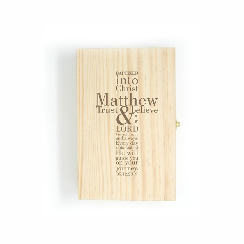 Op de afbeelding: Een houten doos met een scharnierend deksel, gegraveerd met de tekst "Baptized into Christ Matthew Trust & believe in the Lord Unconditionally and always. Every day be thankful and He will guide you on your journey. 05.12.2019"