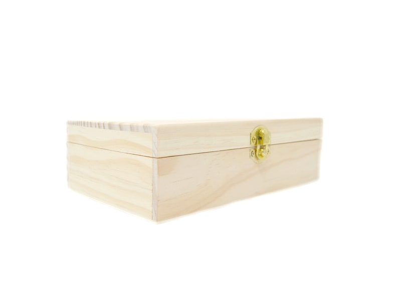 Op de afbeelding: Een eenvoudige houten doos met een scharnierend deksel en een messing sluiting. De doos is gemaakt van licht hout en heeft een natuurlijke afwerking.