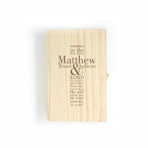 Op de afbeelding: Een houten doos met een scharnierend deksel en een messing sluiting. De doos is gegraveerd met de tekst "CONFIRMED in the Holy Spirit Matthew Trust & believe in the LORD Unconditionally and always. Every day be thankful and He will guide you on your journey. 05.12.2019"