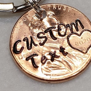 May include: A copper penny keychain with the words "CUSTOM Text" and a heart with the year "2020" engraved on it.