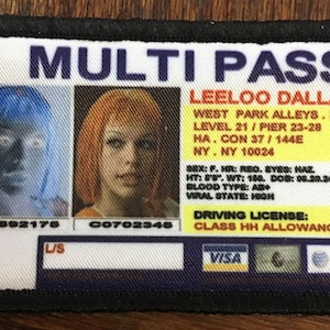 May include: A white multi-pass card with a blue and orange photo ID. The card reads "MULTI PASS" in large purple letters and "LEELOO DALLAS" in black letters. The card also includes a driving license with the text "CLASS HH ALLOWANCE".