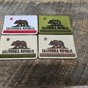 May include: Four embroidered patches featuring the California Republic flag design. Each patch has a bear, star, and the words "CALIFORNIA REPUBLIC." The patches are in white, olive green, and tan with red, green, and brown borders.