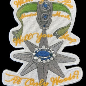 May include: A white embroidered patch with a silver star and a blue jewel in the center. The star is surrounded by a yellow scroll with the text "When you are Hundred Years Old Will you Stop At Only Words?"