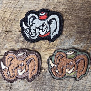 May include: Three embroidered patches featuring a cartoon elephant with a hat. The top patch is gray, red, and black. The bottom left patch is brown and tan. The bottom right patch is brown and green.