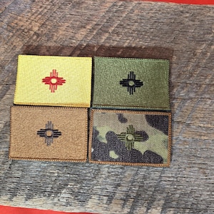 以下が含まれることがあります： ニューメキシコ州のシンボルが刺繍されたパッチが4つ。パッチは黄色、緑、茶色、迷彩など、さまざまな色とパターンでデザインされています。