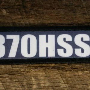 May include: A black patch with white text that reads "370HSSV".