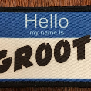 May include: A blue and white name tag with black text that reads "Hello my name is GROOT".
