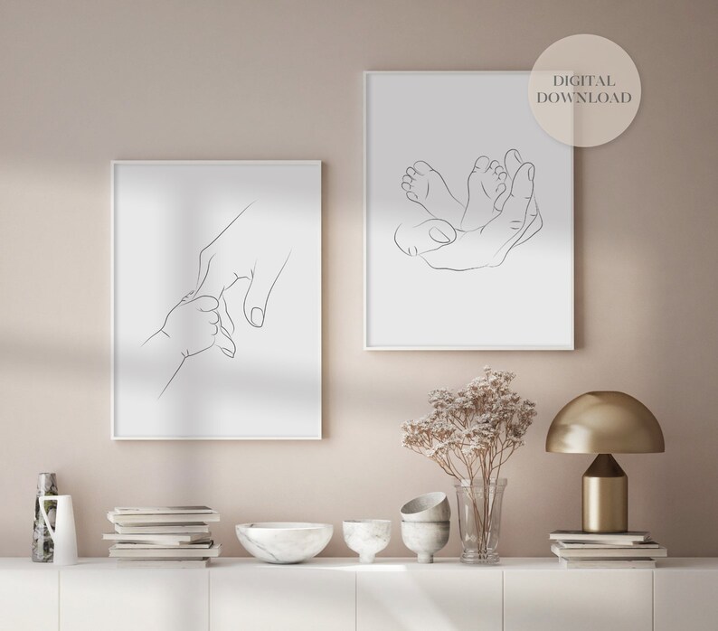 Puede incluir: Dos grabados enmarcados de arte lineal minimalista. Uno representa una mano sosteniendo la mano de un beb&eacute;, el otro muestra una mano acunando los pies del beb&eacute;. Los grabados est&aacute;n en marcos blancos con un fondo neutro. El texto "DESCARGA DIGITAL" est&aacute; en un c&iacute;rculo en el grabado de la derecha.