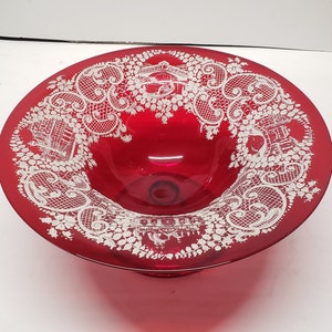 以下が含まれることがあります： 縁に白いレース模様が施された赤いガラス製のボウル。ボウルは足付きです。