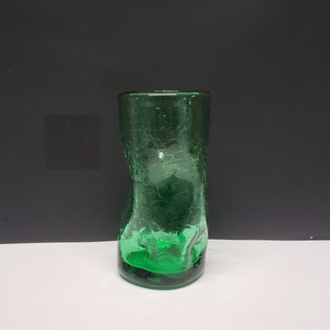 May include: A green glass shot glass with a textured surface.