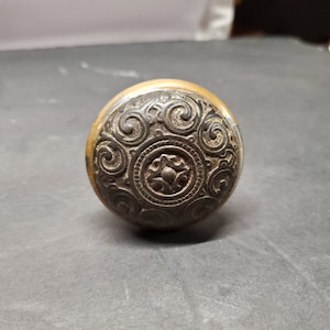 Pomolo per porta in ottone anticato con decoro in rilievo