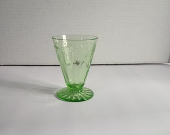 Peut inclure: Un verre à dessert vert avec un motif évasé et gravé. La coupe a une base ronde et un bol conique. Le verre a une teinte vert clair. La coupe est probablement vintage ou antique.