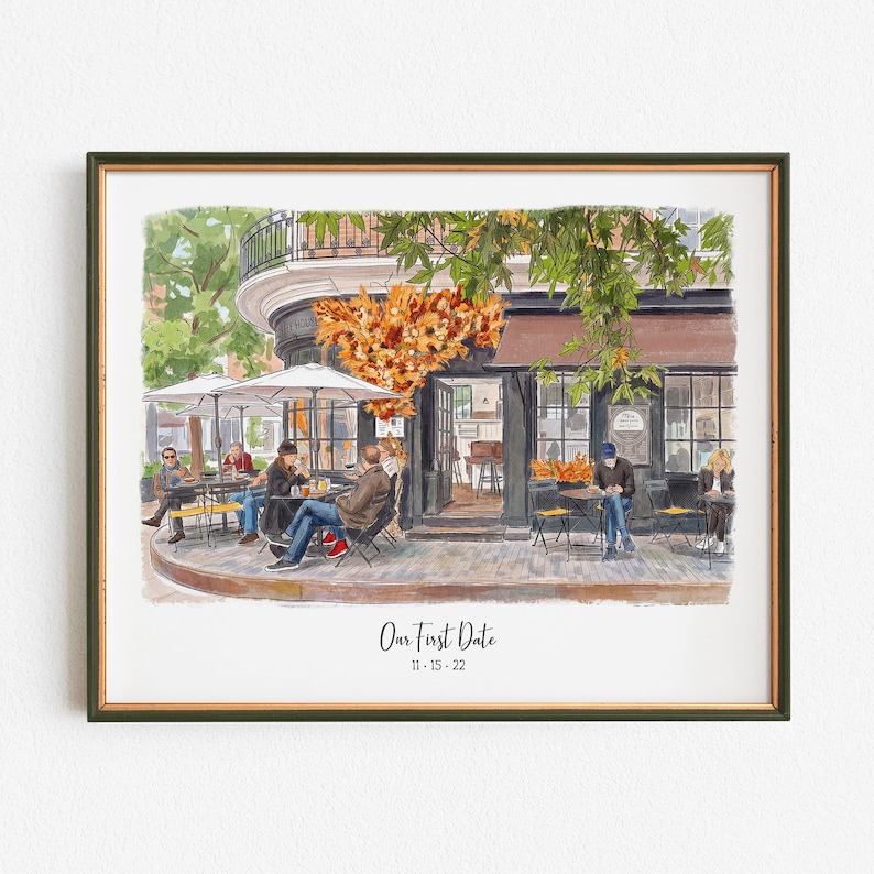May include: Watercolor print of a cafe scene with people seated at outdoor tables. The cafe has a brown awning and large windows. The print includes the text "Our First Date" and the date "11-15-22". The print is framed in a dark green frame.