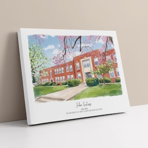 May include: A canvas print featuring a watercolor illustration of a brick building with a green lawn and trees. The artwork includes the name "John Galassi" and the years "1962-2025", along with the quote "The influence of a great leader can never be erased."