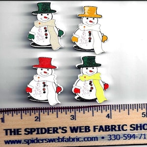 May include: Four wooden snowman buttons with different colored hats. The snowmen are wearing scarves and have red cheeks. The buttons are approximately 2 inches in diameter.