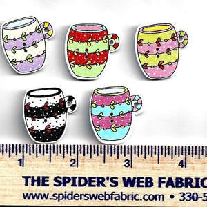May include: Five wooden buttons shaped like mugs, each with a unique design. The mugs feature colorful patterns, including polka dots, stripes, and floral accents. The text "THE SPIDER'S WEB FABRIC" is visible at the bottom.