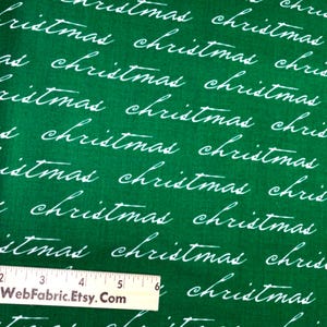 May include: Green fabric with white cursive text that reads "christmas" repeatedly. A ruler is at the bottom of the image. The text "WebFabric.Etsy.Com" is on the ruler.