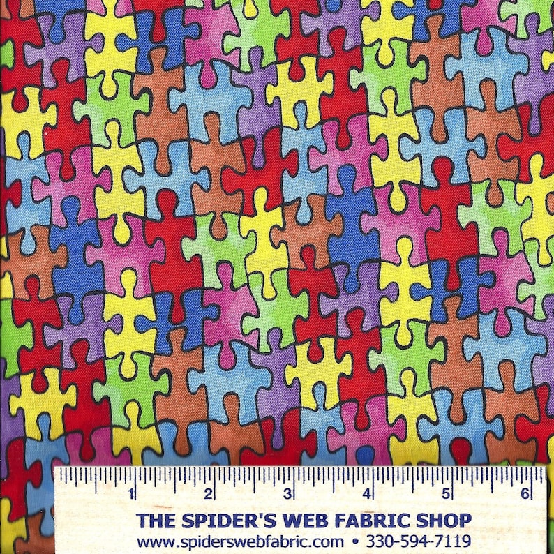 May include: A colorful fabric with a repeating pattern of puzzle pieces in various colors, including red, blue, green, yellow, and purple. The puzzle pieces are outlined in black and have a slightly faded, watercolor-like effect.