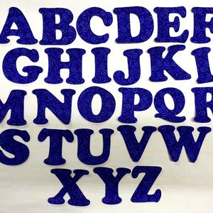 May include: A full alphabet of uppercase letters, each cut from blue fabric with a swirling pattern. The letters are arranged in rows, from A to Z, against a white background. Ideal for crafting or educational projects.