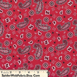 May include: Red fabric with a paisley pattern in black and white. The fabric is a bandana print.