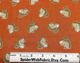 Può includere: Tessuto arancione con un motivo ripetitivo di scoiattoli marroni. Il tessuto è misurato con un righello che riporta "SpiderWebFabric.Etsy.Com".