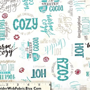 以下が含まれることがあります： 白地にターコイズ、茶色、金色のテキストが繰り返しパターンで描かれた生地。テキストには「ホットココア」、「温かい心地よい」、「甘いココア」、「一緒にいよう」などのフレーズが含まれています。