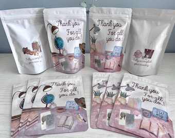 Puede incluir: Bolsas blancas con ilustraciones de acuarela y texto. Las bolsas presentan ilustraciones de un escritorio con un globo terráqueo, libros y una lámpara. El texto en las bolsas dice "Thank you for all you do!" y "Fully accomplish your ministry."