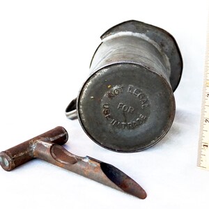 May include: A vintage metal oil can with a spout and a handle. The can is labeled "Not Legal For Use In Trade".
