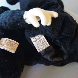 May include: Black plush Mickey Mouse puppet with a white glove hand. The puppet has two tags that say "Applause" on them.