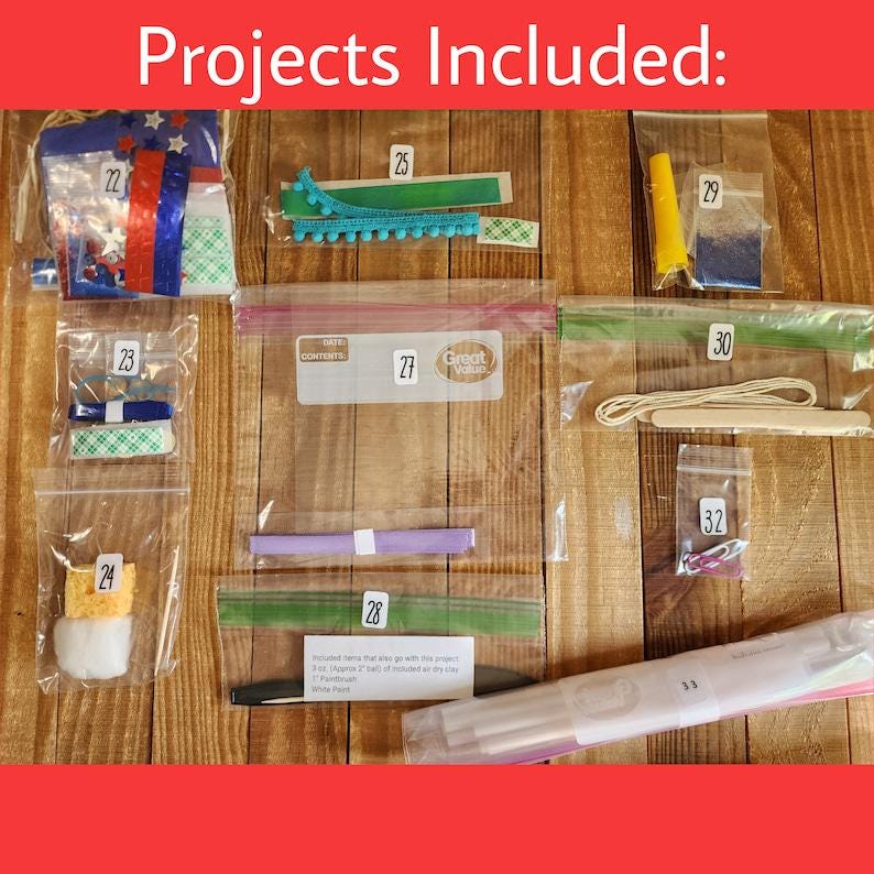 May include: A collection of craft supplies organized in clear plastic bags labeled with numbers 22 through 33. The bags contain various items including ribbons, foam tape, a yellow cone, string, wooden sticks, a sponge, and white clay components.