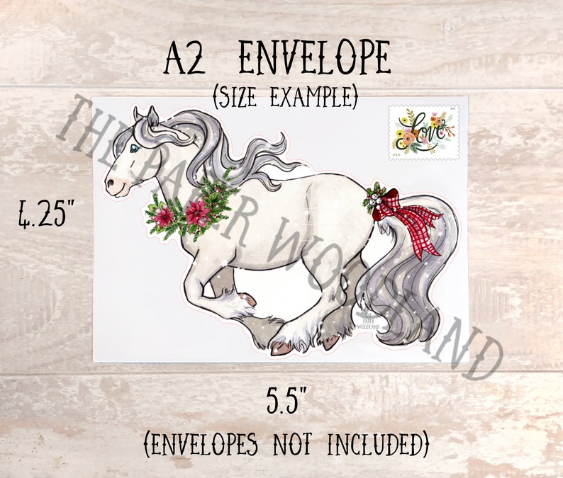 May include: A2 envelope with a watercolor illustration of a white horse with a gray mane and tail, adorned with a Christmas wreath and a red plaid bow. The envelope measures 4.25 x 5.5 inches.