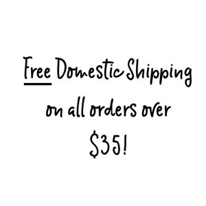 May include: Black handwritten text on a white background. The text reads "Free Domestic Shipping on all orders over $35!"