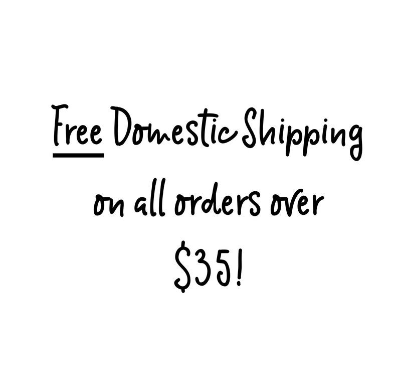 May include: Black handwritten text on a white background. The text reads "Free Domestic Shipping on all orders over $35!"