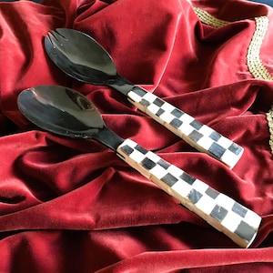 Peut inclure: Un ensemble de deux serveurs à salade à carreaux noirs et blancs avec des manches en corne noire. Les serveurs sont posés sur une surface en velours rouge.