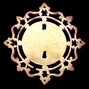 Antigua placa de llave francesa de latón ornamentada, diámetro 12 cm, década de 1920, restaurada.