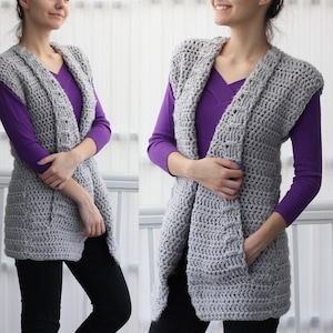 May include: A gray crochet vest with a deep V-neck and pockets. The vest is worn over a purple shirt.