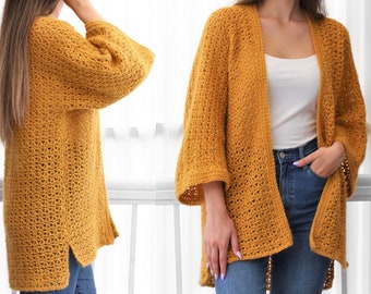 Op de afbeelding: Een mosterdgele gehaakte cardigan met een losse pasvorm en lange mouwen. De cardigan is open aan de voorkant en heeft een eenvoudig, elegant ontwerp.