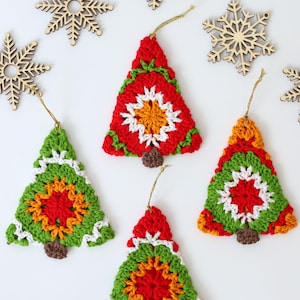 Puede incluir: Cinco adornos de &aacute;rbol de Navidad de ganchillo en rojo, verde, blanco, naranja y marr&oacute;n. Los adornos cuelgan de una cuerda dorada.