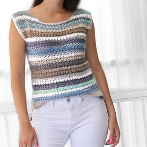May include: A striped crochet top with a scoop neck and short sleeves. The top is made with a variety of blue, brown, white, and green yarn.