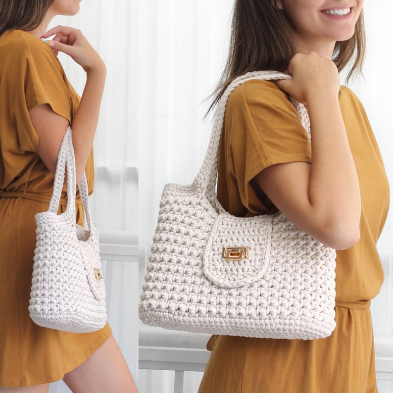 Puede incluir: Un bolso tote de crochet blanco con un cierre dorado. El bolso tiene un dise&ntilde;o texturizado y tejido y lo lleva una persona con un vestido amarillo mostaza.