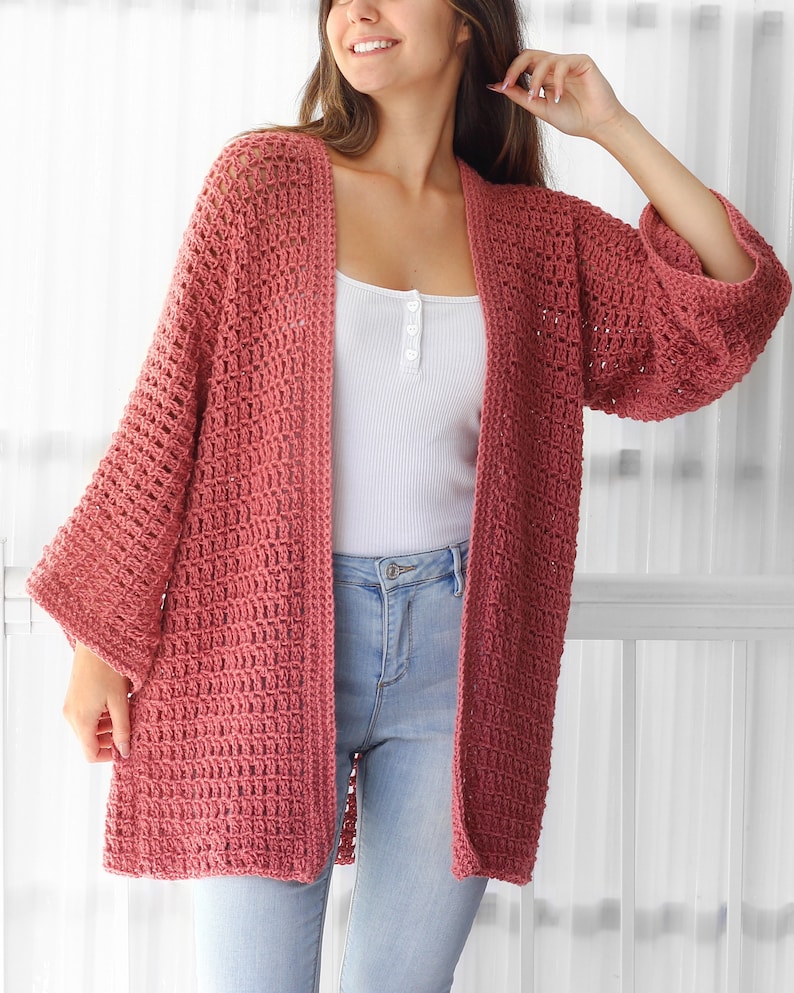 Pu&ograve; includere: Un cardigan lungo in crochet con apertura frontale, di colore rosa polvere. Il cardigan ha una vestibilit&agrave; ampia e una silhouette ampia e fluida. &Egrave; realizzato con un delicato motivo a punto aperto.