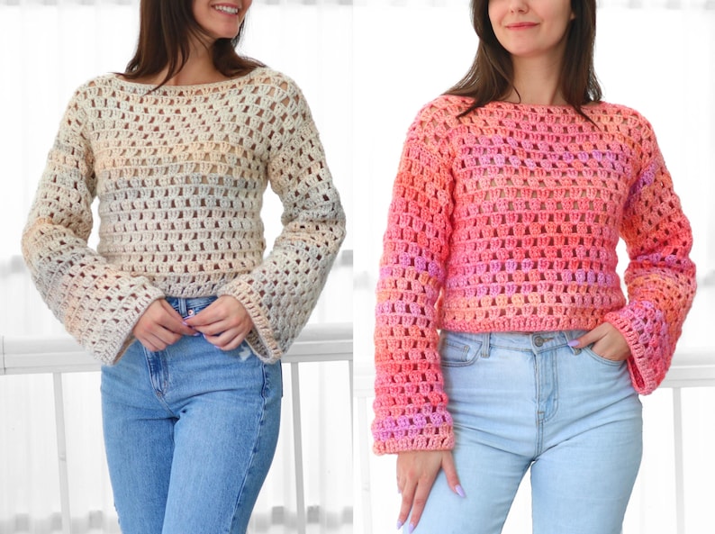 May include: Two crochet sweaters, one in cream and the other in shades of pink and orange. Both sweaters have a loose, open weave design with long, flared sleeves and a boat neck. The sweaters are paired with blue jeans.
