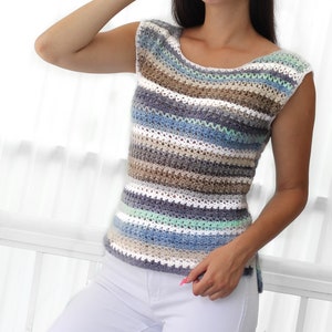 May include: A striped crochet top with a scoop neck and sleeveless design. The top is made with a variety of colors, including white, blue, green, and brown.